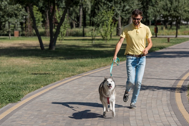 Отец гуляет с собакой в парке