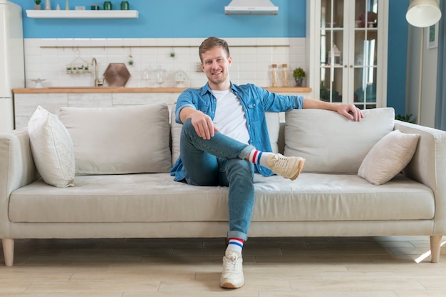 Free photo father wearing casual clothes and sitting on sofa