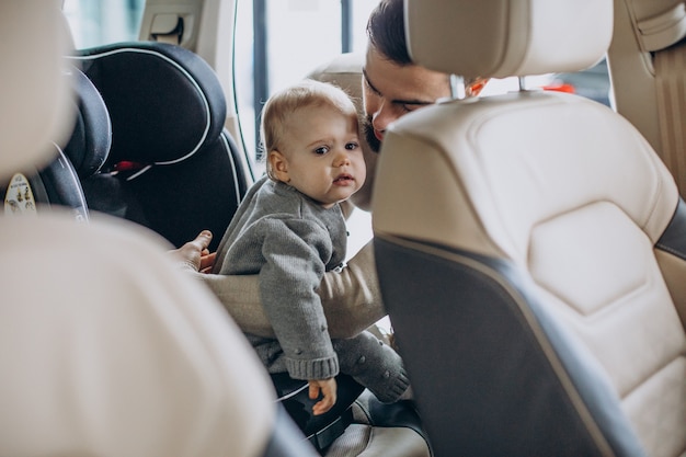 Father with baby daughter in a car showroom