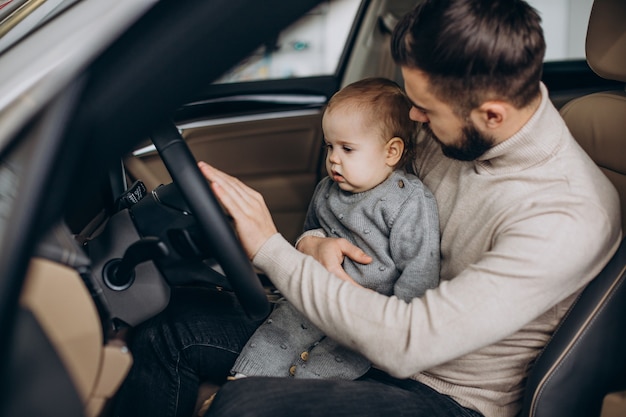 Free photo father with baby daughter sitting in car