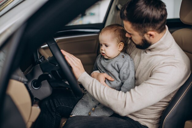 Father with baby daughter sitting in car