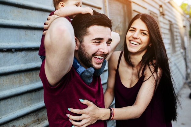 Father with baby on shoulders and mother laughing