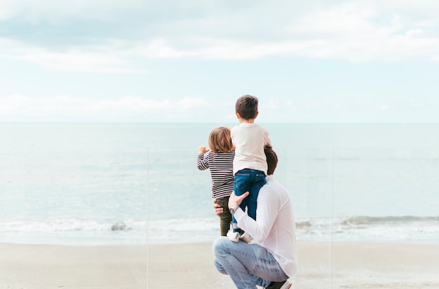 Padre con ragazzi che guardano il mare