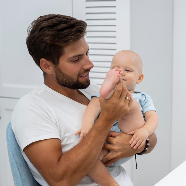 Foto gratuita padre con bambino a casa durante la quarantena