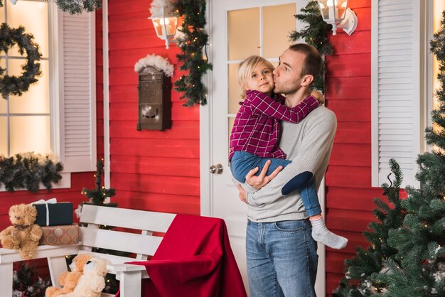 家の前でクリスマスに娘と父親