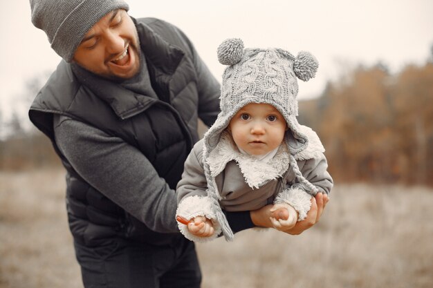 Father with little daughter playing in a spring field