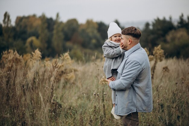 Father with little daughter together in autumnal weather having fun