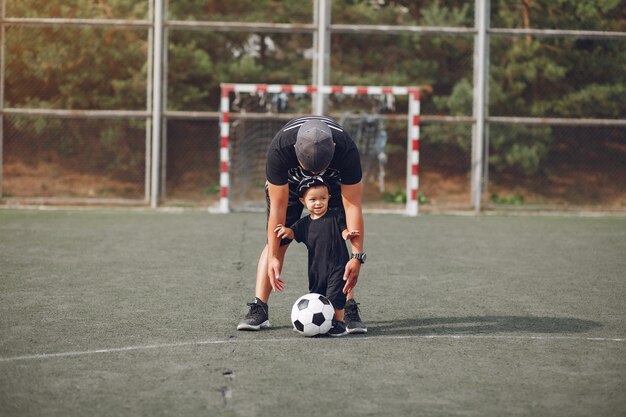 Father with little son playing football