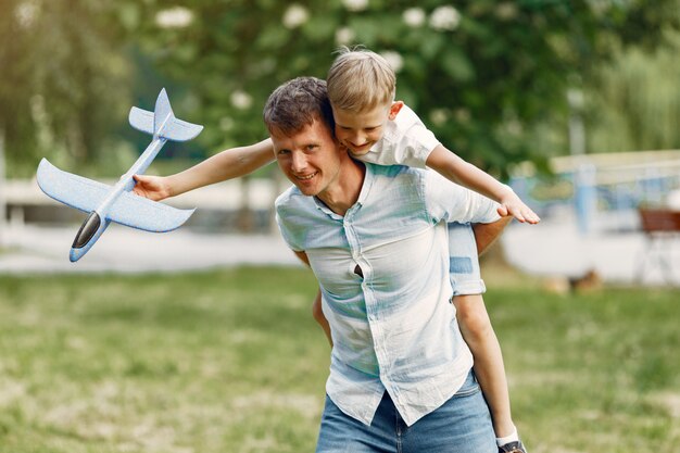 Father with little son playing with toy plane