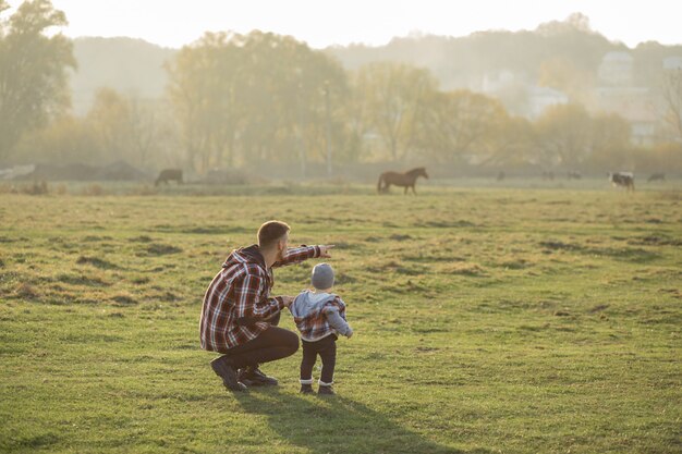 Father with little son walking in a morning field