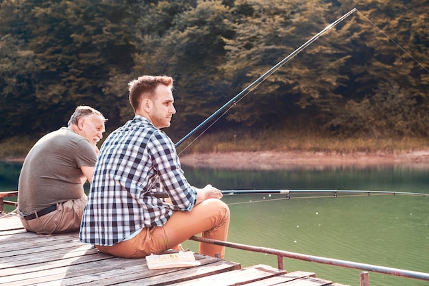 Foto gratuita padre con figlio pesca sul molo