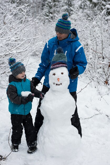 Father with son making snowman