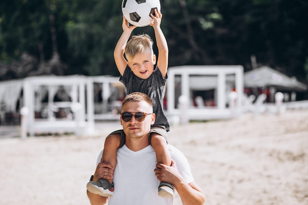 ビーチでサッカーの息子と父