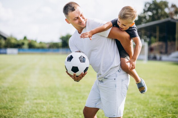 Father with son playing football at the field