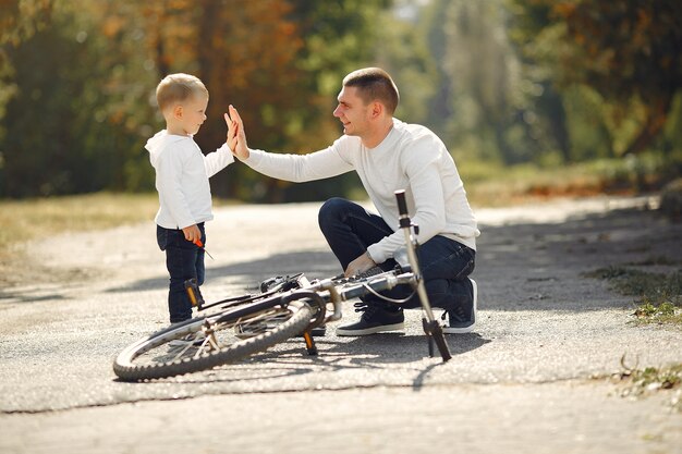 Free photo father with son repare the bike in a park