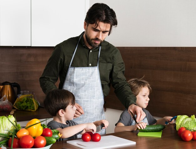 Father with sons in kitchen cooking