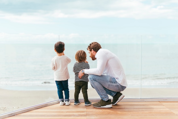 Free photo father with sons looking at sea