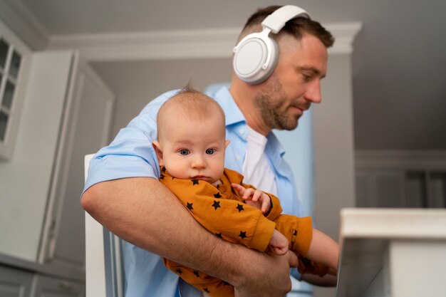 Father working from home trying to balance family life with child and job