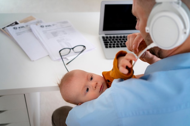 Father working from home trying to balance family life with child and job