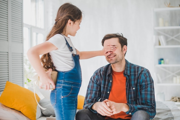 Fathers day concept with daughter covering fathers eyes