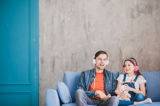 Free photo fathers day concept with father and daughter listening to music