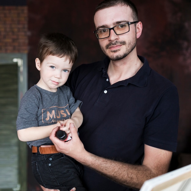 Foto gratuita concetto di giorno di padri con padre e figlio di fronte a tela