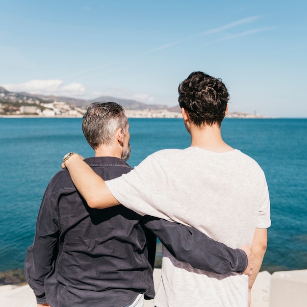 Fathers day concept with father and son in front of sea