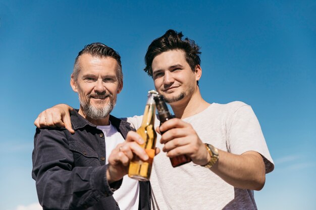 Fathers day concept with father and son posing with beer