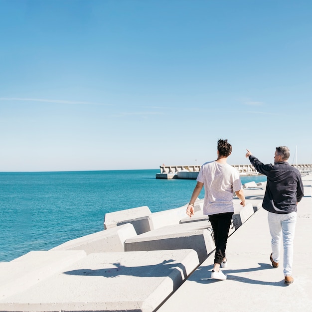 fathers day concept with father and son walking next to sea