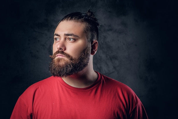 Fatty bearded male in a red t shirt on grey background.