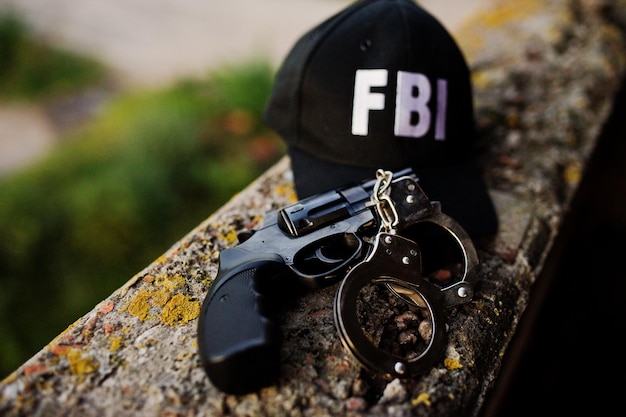 리볼버와 수갑이 있는 FBI 모자