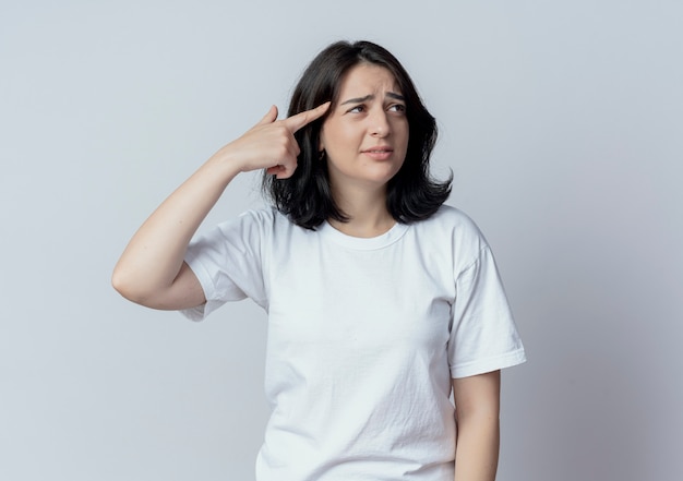 Fed up young pretty caucasian girl looking at side and doing suicide gesture isolated on white background with copy space