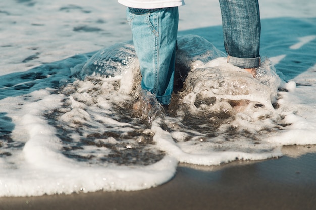 Foto gratuita piedi di bambino e madre in piedi in mare