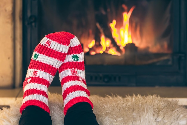 Free photo feet in christmas socks in front of the fireplace closeup