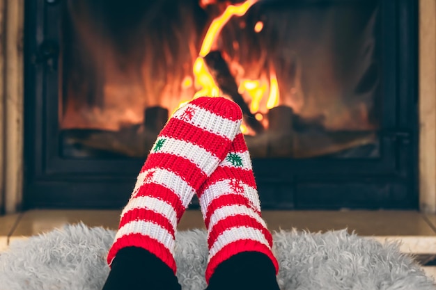 Free photo feet in christmas socks in front of the fireplace closeup