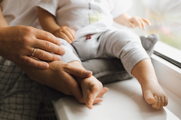 両親の腕の中で小さな男の子の足