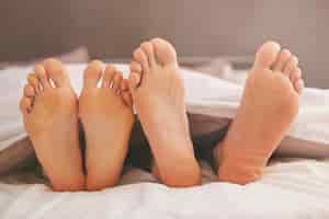 Бесплатное фото Ноги пары в удобной кровати