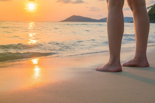 Feet on the sand in sunset time