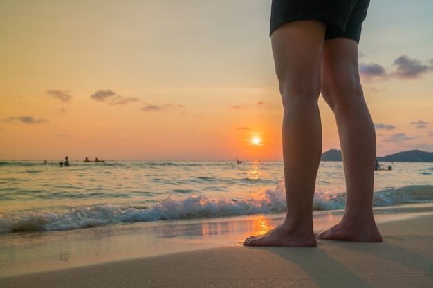Feet on the sand in sunset time