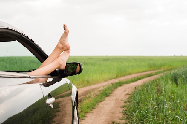 Piedi di donna che guarda fuori dal finestrino della macchina