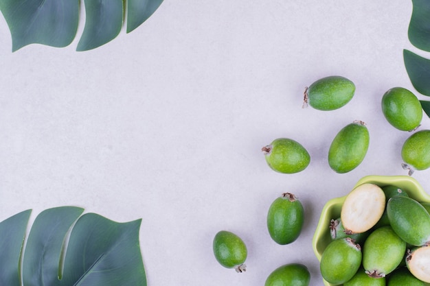 Free photo feijoas in a green cup on grey surface