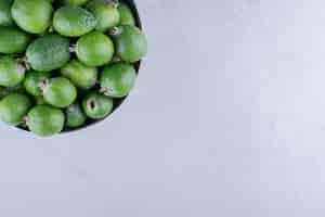 Free photo feijoas piled into a metal vase on marble background. high quality photo