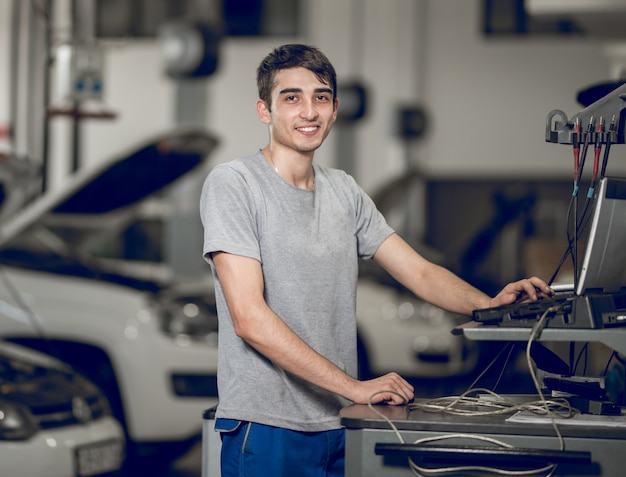 A fellow benchman computering and diagnosing, detecting the problems of a car