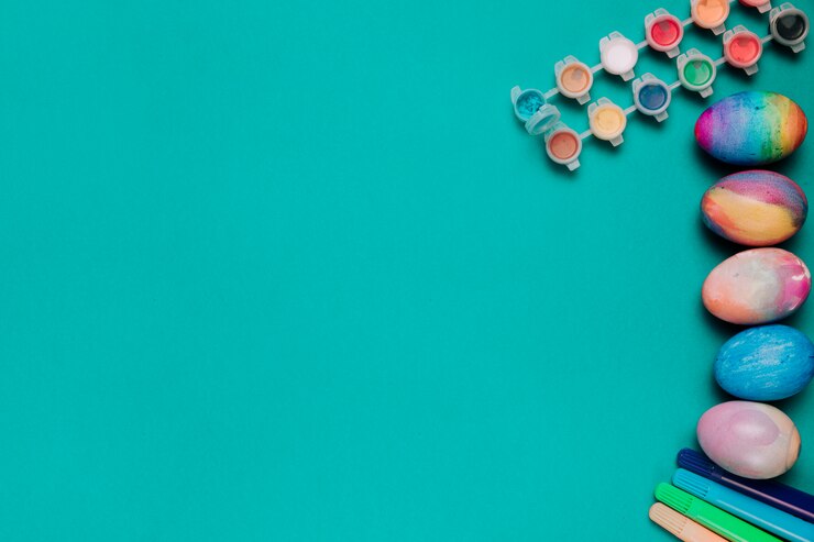 Free Photo felt tip pen; water color plastic bottles and painted easter eggs on green background with copy space