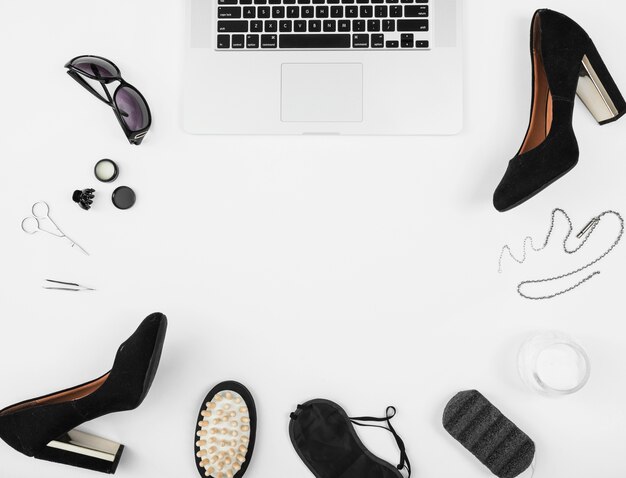 Female accessories with an open laptop on white background