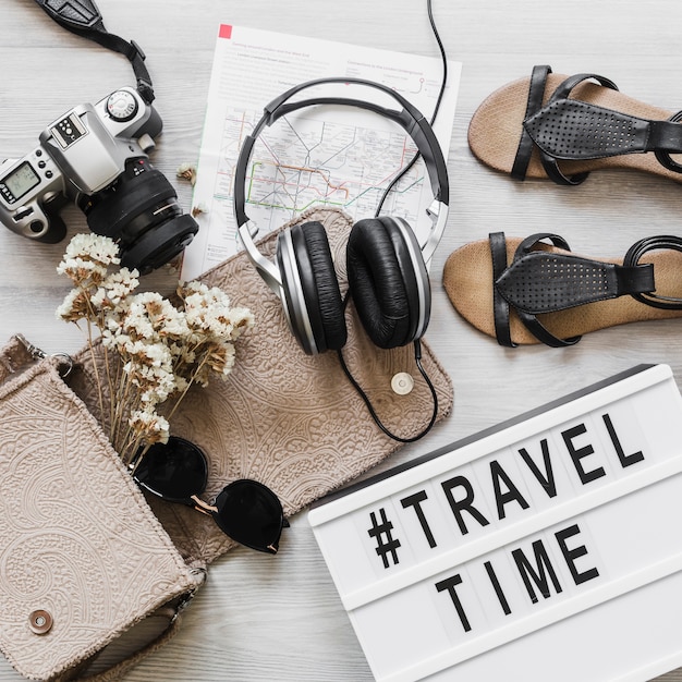 Foto gratuita accessori femminili con testo di viaggio e il tempo sul tavolo di legno