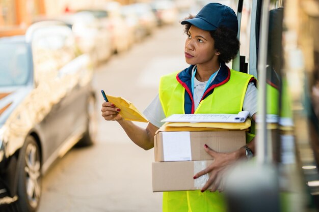 Female African American courier delivering packages in the city