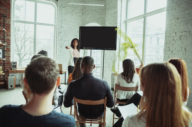 Female african-american speaker giving presentation in hall at university workshop