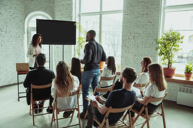 Female african-american speaker giving presentation in hall at university workshop