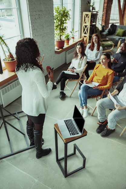 Female african-american speaker giving presentation in hall at university workshop